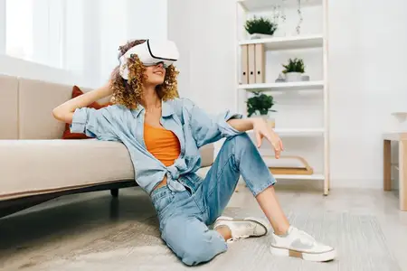 Улыбающаяся женщина наслаждается игрой в виртуальной реальности дома