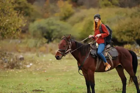 Женщина-туристка путешествует по горам, наслаждаясь природой и верхом на лошади на фоне живописного пейзажа