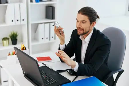 Менеджер работает в офисе перед ноутбуком, используя современные технологии