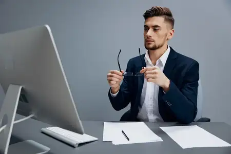 Бизнесмены в очках работают за компьютером на сером фоне