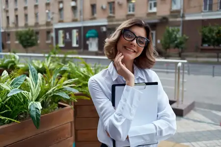 Веселая деловая женщина с документами, общение на улице