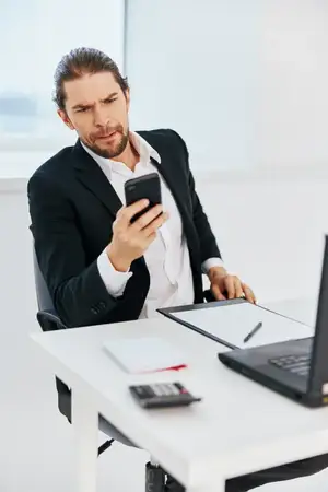 Деловые люди в офисе работают с документами, в руке телефон