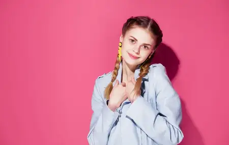 Женщина с хвостиками, украшениями и серьгами на розовом фоне