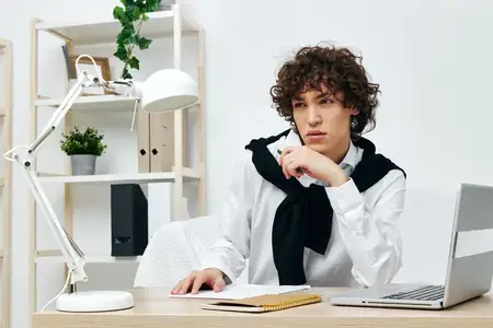 Парень занимается онлайн-обучением за ноутбуком в интерьере дома