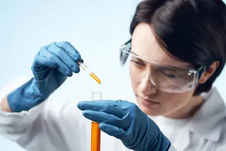 Женщина-лаборант в белом халате работает с химическим раствором в пробирке, занимаясь наукой