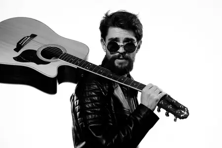 Мужчина держит в руках гитару