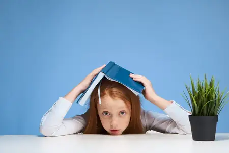 Рыжеволосая девушка делает домашнее задание дома, образование, обучение