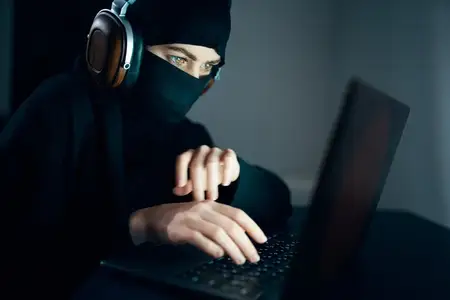 Женщина ночью сидит перед ноутбуком в наушниках, интернет-технологии