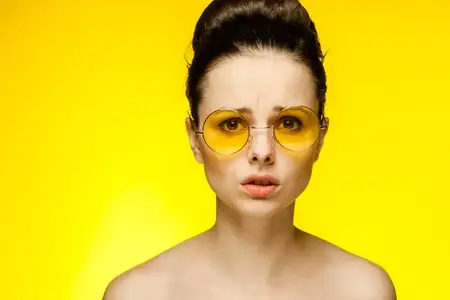 Симпатичная женщина веселится, жёлтые очки, обнажённые плечи