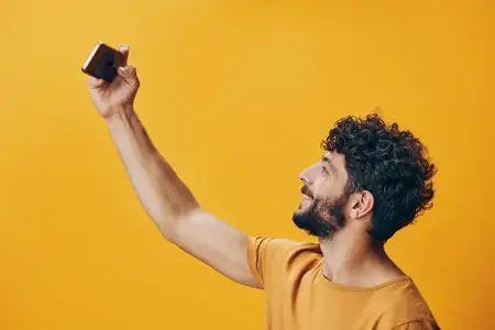 Мужчина держит черное устройство — смартфон, смотрит в него