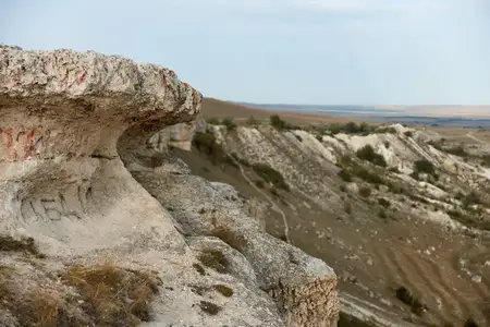 Величественные скальные образования с граффити и человек, стоящий на краю обрыва в красивом пейзаже