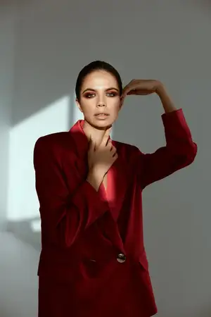 Женщина с ярким макияжем на лице, красная куртка, украшение, модель роскоши