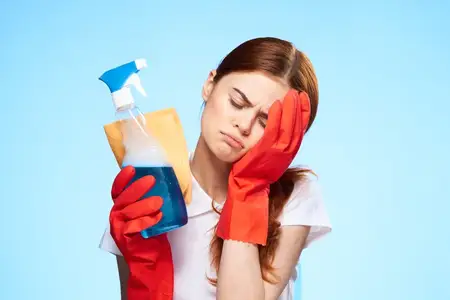 Уставшая уборщица держится за голову