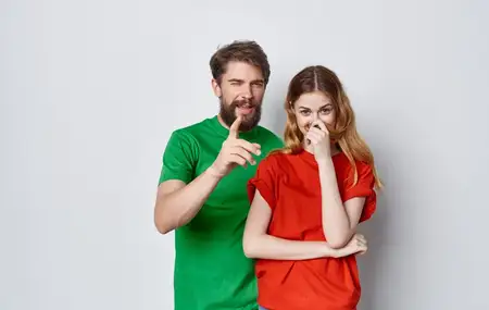 Забавные мужчина и женщина в разноцветных футболках, эмоции, жесты рук, дружба