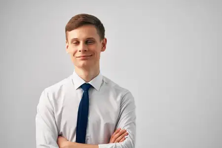 Мужчина в рубашке с галстуком позирует в офисе