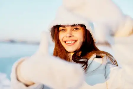 Симпатичная женщина с рыжими волосами на заснеженном поле в зимней одежде во время путешествия