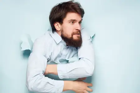 Эмоциональный мужчина прорывается сквозь фон