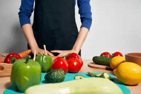 Повар на кухне нарезает овощи, диетическое питание