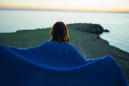 Женщина-туристка любуется природным пейзажем с рекой, вид со спины