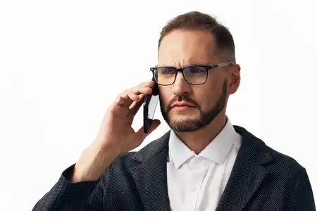 Корпоративный руководитель сохраняет спокойное, решительное настроение во время разговора по телефону, с уравновешенным взглядом, на изолированном цветном фоне, который подчеркивает…