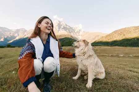 Женщина и собака в горах на природе