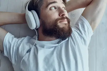 Молодой человек лежит на подоконнике в наушниках