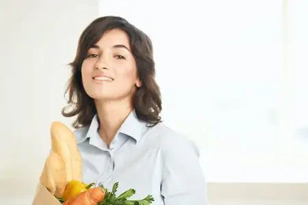 Брюнетка с букетом продуктов, овощами в супермаркете, на кухне, готовит