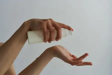 Лосьон в руках женщины, крупный план, чистая кожа, увлажнение
