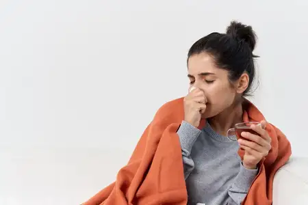 Больная женщина с чашкой чая лечится от инфекции дома