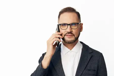 Профессиональный руководитель-мужчина на ярком цветном фоне демонстрирует решимость и ясность во время разговоров по телефону, представляя уравновешенное и внимательное отношение для корпоративного…
