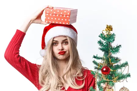 Радостная женщина с рождественскими подарками на светлом фоне