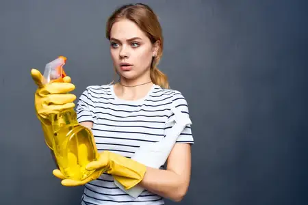 Домохозяйка использует моющее средство, тряпки и губки для оказания услуг