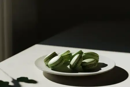 Аппетитные зеленые макароны, поданные на белой тарелке, освещенные естественным светом, идеально подходят для тем гурманских десертов и современных кулинарных презентаций