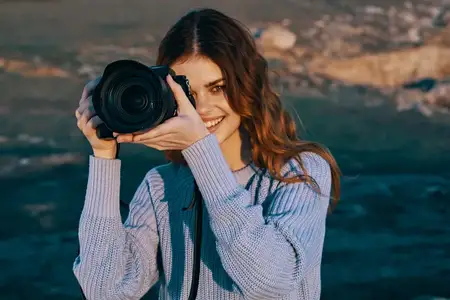 Женщина-турист с фотоаппаратом наслаждается пейзажем и природой во время отпуска и путешествия