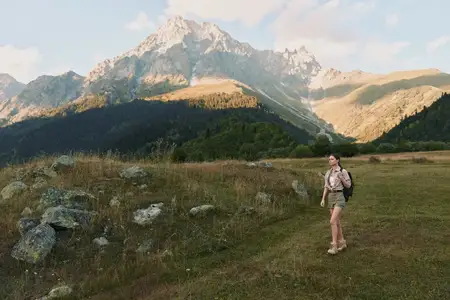 Непринужденный вид женщины на тропе в альпийской местности, наслаждающейся природой, свежим воздухом и открытым пространством, подчеркивающий фитнес, путешествия и осознанную жизнь на природе