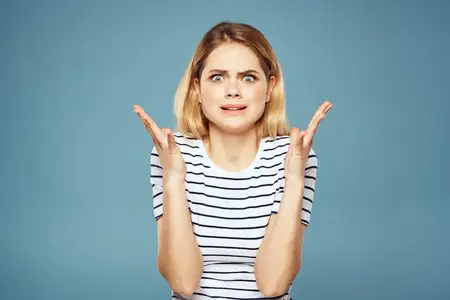 Расстроенная женщина, эмоции, недовольство, жесты руками на голубом фоне