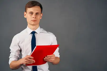 Весёлый мужчина в рубашке с галстуком, красная папка с документами, менеджер на тёмном фоне