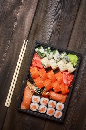 Палочки для еды, роллы суши, азиатская кухня на деревянном столе, имбирь и васаби