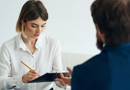 Женщина и мужчина в деловых костюмах общаются, держа документы и резюме
