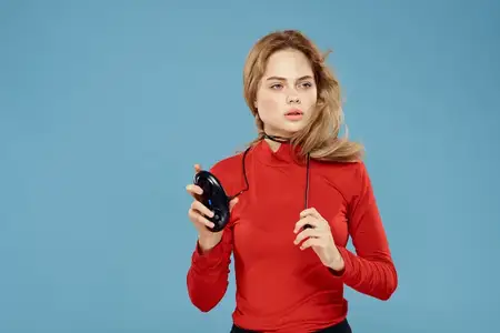 Симпатичная женщина с геймпадом в руках, игры, развлечения, консоли, образ жизни, синий фон, красная куртка