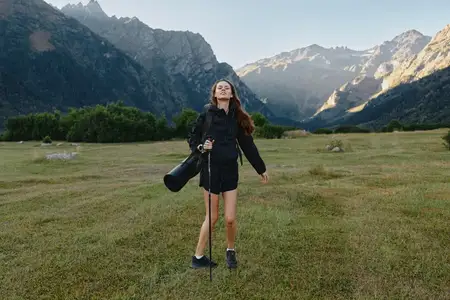 Фотограф смотрит на далекие пики, готовый снимать, олицетворяя исследование, подготовку и искусство на открытом воздухе среди бескрайних пейзажей