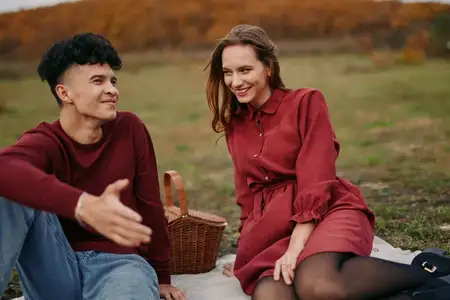 Уютная сезонная сцена, запечатлевшая расслабленный разговор и связь во время осенней прогулки, подчеркивающая искренние эмоции, спонтанный смех и достоверную повседневную романтику