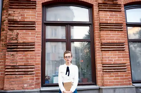 Симпатичная женщина на улице возле здания отдыхает