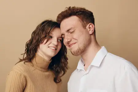 Близкая нежная молодая пара с закрытыми глазами и мягкими улыбками