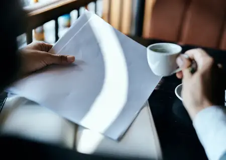 Бизнес-леди в кафе с книгой на столе, документами и чашкой кофе, работа, образ жизни