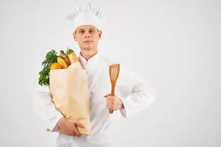 Шеф-повар с упаковкой свежих продуктов на кухне, профессиональная работа