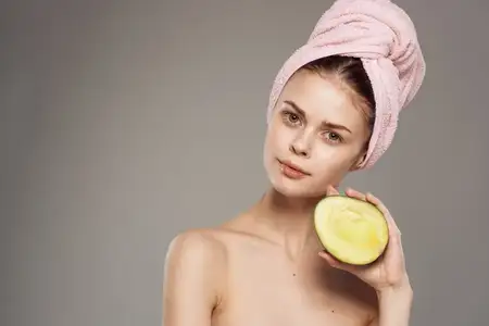 Женщина с обнаженными плечами, чистой кожей, здоровьем, витаминами, крупным планом манго