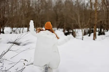 Женщина гуляет по зимнему полю, отдыхая на свежем воздухе во время зимних каникул