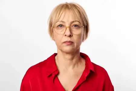 Пожилая женщина в красной рубашке и очках