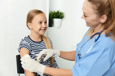 Женщина-врач делает инъекцию в руку ребенка в больнице